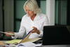 Woman looks at records in simple office